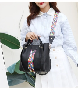 Detailansicht schwarze Handtasche mit Narbenleder und buntem geometrischem Schultergurt