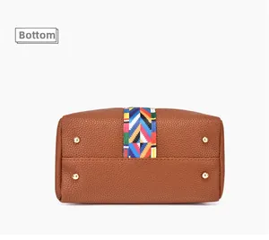 Detailansicht des Taschenbodens mit goldenen Metallfüßen und buntem gewebtem Zierband