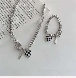 Détail du collier cœur en damier argenté avec fermoir OT et plaque rectangulaire