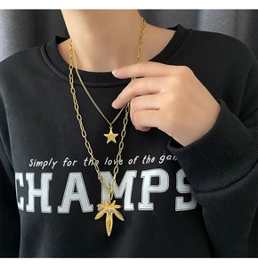 Close-up of double-layer gold titanium steel necklace with star and maple leaf pendants