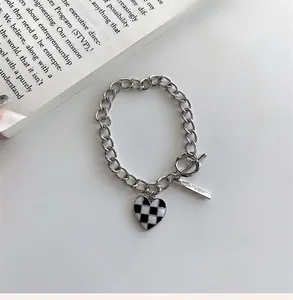 Détail du bracelet cœur à damier avec fermoir à bascule et texture argentée