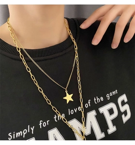 Close-up of a double-layered gold paperclip chain necklace with a star pendant for women