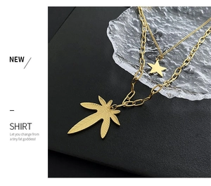 Detail of gold double-layer chain necklace featuring star and maple leaf pendants