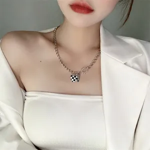 Collier cœur en damier argenté avec chaîne épaisse et fermoir OT sur le mannequin