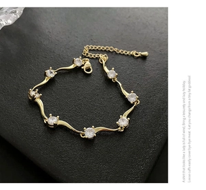 Détail macro du bracelet doré en forme de vague orné de zircons étincelants