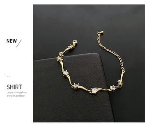 Vue détaillée du bracelet en chaîne dorée avec design ondulé et pierres en zircon