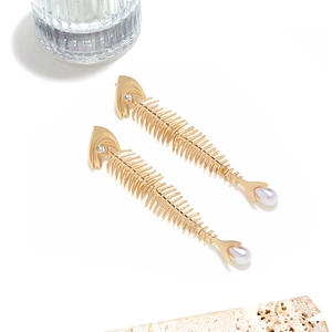 Vintage gold fishbone drop earrings with faux pearls and rhinestones on white background