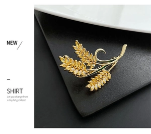 Detailed view of golden wheat brooch with inlaid yellow zircon on black background