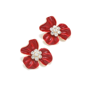 Détail de boucles d'oreilles fleurs en émail rouge avec cristaux et plaqué or