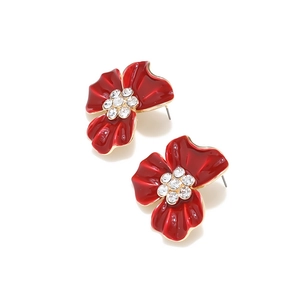 Détail de boucles d'oreilles fleurs en émail rouge avec bords dorés et cristaux