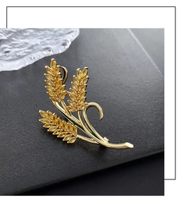 Macro detail of golden wheat ear brooch with sparkling yellow stones on dark textured surface
