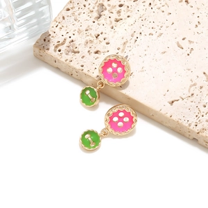 Detailed close-up of double-layered pink and green enamel button pendant earrings