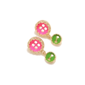 Detail of pink and green enamel button earrings with gold scalloped metal edges