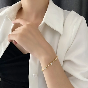 Bracelet doré élégant avec zircons blancs scintillants porté au poignet d'une femme