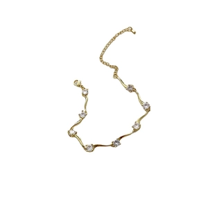 Bracelet doré ondulé exquis pour femme orné de pierres rondes en zircone cubique brillante