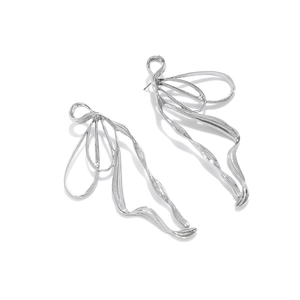 Macro detail of high-polish silver streamline butterfly ribbon earring with glossy finish