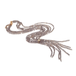 Detailed view of layered smoke grey crystal beads and intricate gold openwork pendant