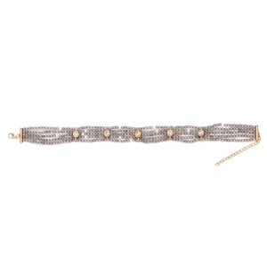 Detailed view of grey beads and gold metal accents with lobster clasp on necklace