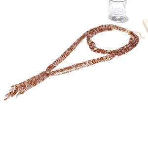 Detail of bohemian layered beaded necklace with purple tassels and adjustable gold clasp