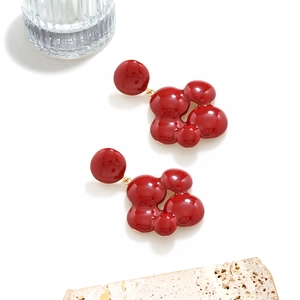 Boucles d'oreilles géométriques émail rouge avec détails dorés sur socle en pierre