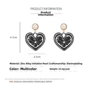 Détail de boucles d'oreilles cœur colorées mesurant 4.7x3.5cm avec détail de perle