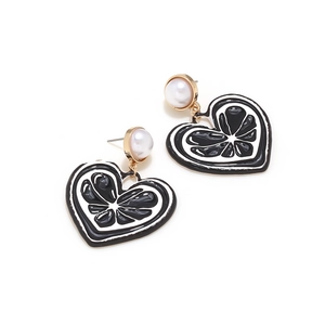 Vue détaillée de boucles d'oreilles cœur en émail avec perles et motif de citron