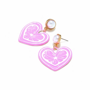 Détail de boucles d'oreilles cœur rose avec motif fruit, perles et monture dorée