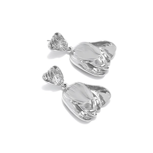 Detailed macro shot of silver tulip flower drop earrings with a metallic mirror finish