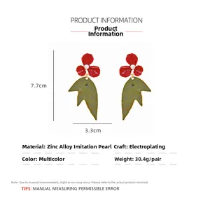 Detail of red floral earrings with pearl center and green leaf pendant showing 7.7cm size