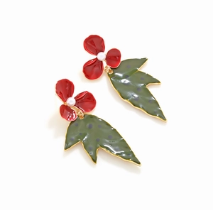 Detail of enamel flower earrings featuring red petals and green polka dot leaves with pearls