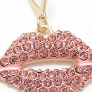 Macro del pendente a labbra con strass rosa, base in metallo dorato e gancio