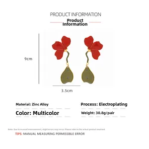 Détail de boucles d'oreilles fleurs de 9x3.5cm avec pétales rouges et feuilles vertes
