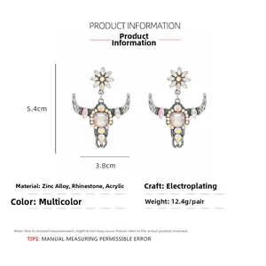 Detail view of bull skull drop earrings with rhinestones showing dimensions 5.4cm by 3.8cm