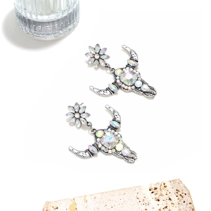 Detail of bohemian cow skull earrings with rhinestones and vintage silver finish