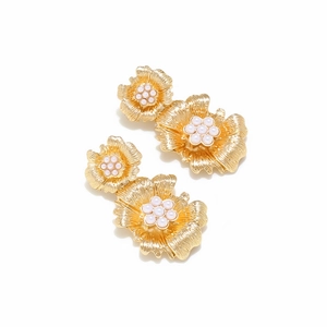Detailed view of gold flower earrings with layered petals and white pearl centers