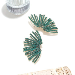 Luxurious gold fan earrings with sparkling green rhinestones on stone background