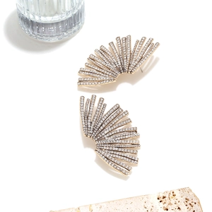Close-up of fan-shaped gold stud earrings with sparkling pavé cubic zirconia accents