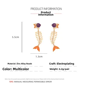 Detail view of purple fishbone earrings with golden framework and dimensions info