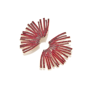 Close-up of fan-shaped gold earrings with sparkling red rhinestones and micro-pave setting