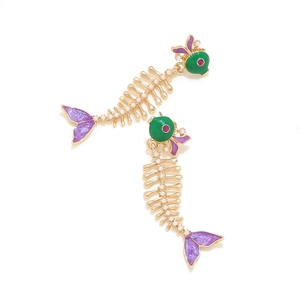 Detailed view of fishbone earrings featuring green enamel and white pearl accents