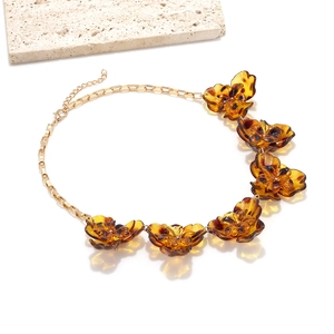 Détail du collier à pendentifs fleurs léopard avec pétales ambrés et chaîne dorée chic