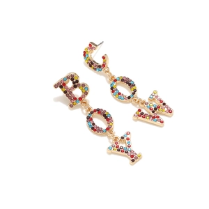 Macro detail of Cowboy gold drop earrings with multi-color rhinestones in BOY and COW motifs