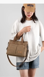 Vue détaillée du sac fourre-tout en toile marron avec logo en cuir et doubles poignées