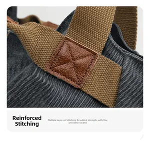 Close-up of reinforced X-shaped stitching and leather patch on canvas tote bag straps