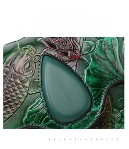 Detailed macro view of the vintage green leather bag with embossed koi and lotus patterns
