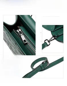 Detail of dark green crocodile embossed handbag featuring durable gunmetal hardware and strap