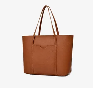 Dettaglio della borsa tote marrone caramello con texture a grana e cuciture decorative