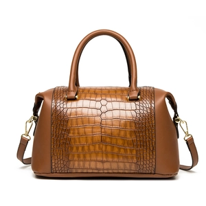 Brown embossed tote bag with top handles and crocodile texture in a classic Boston style