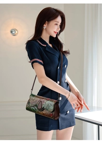 Detail of vintage embossed leather crossbody bag with floral pattern worn by model