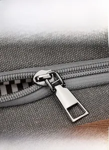 Vue macro d'une fermeture éclair en alliage sur un sac en toile grise avec doublure
